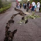 La gente camina por la carretera sorteando el surco abierto en la calzada por un fuerte terremoto en Chiapas, México.