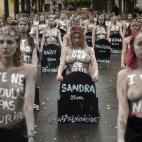 TOPSHOT - Femen activists hold placards shaped as tombstones, reading the name and the age of each women killed this year by their partner in 2019, during a protest action dedicated to the memory of the women killed by their partner or ex-partne...