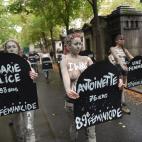 Femen activists hold placards shaped as tombstones, reading the name and the age of each women killed this year by their partner in 2019, during a protest action dedicated to the memory of the women killed by their partner or ex-partner and agai...