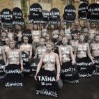 Femen activists hold placards shaped as tombstones, reading the name and the age of each women killed this year by their partner, during a protest action dedicated to the memory of the women killed by their partner or ex-partner and against the ...