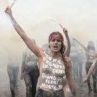 A Femen activist, with "I'll be considered seriously when I will be dead." written on her chest, holds a flare during a protest action dedicated to the memory of the women killed by their partner or ex-partner and against the violence against wo...