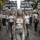 TOPSHOT - Leader of the feminist activist group Femen Inna Shevchenko (front) and Femen activists hold placards reading "More heard dead than alive", "I didn't want to die" during a protest action dedicated to the memory of the women killed by t...