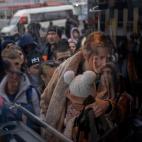 Una mujer sujeta su beb&eacute; mientras sube a un autob&uacute;s para marcharse de Kiev. (AP Photo/Emilio Morenatti)