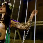 An activist of women's rights organisation Femen, is chained to the gate of Palacio Vistalegre, with the words "against fascist vote" painted on her body, early on October 6, 2019 in Madrid, during a protest against a campaign rally of Spanish f...