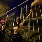 Activists of women's rights organisation Femen, are chained to the gate of Palacio Vistalegre, with the words "against fascist vote" painted on their body, early on October 6, 2019 in Madrid, during a protest against a campaign rally of Spanish ...