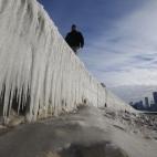 Un ciudadano observa un muro de hielo formado alrededor de una playa, en Chicago