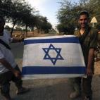 Dos soldados muestran una bandera israelí.