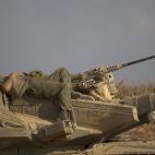 Un soldado descansa sobre un tanque.