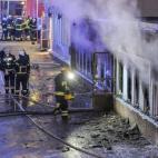 Los bomberos tratan de sofocar el fuego que se ha producido en el sótano de una mezquita en Eskilstuna, Suecia, en donde se encontraban rezando veinte personas, al parecer por el impacto de un objeto incendiario.