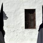 Cuatro nazarenos de la Hermandad de la Sangre se dirigen el Martes Santo a la Iglesia de los Capuchinos de Córdoba antes de comenzar la estación de penitencia.