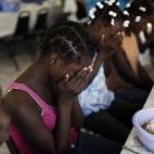 Children pray before lunch time in a orphanage used by U.N. children's agency UNICEF for Haitian children separated from parents after the Jan. 12 earthquake in the outskirts of Port-au-Prince, Wednesday, Jan. 27, 2010. UNICEF has brought eight ...