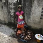 Twelve-year-old, Kemi Olajuwon, who has to drop out of school some days to sell smoked fish and make money so there can be food in the house, and also for her school fees, displays her fish on the street in the Obalende area of Lagos, Nigeria, T...