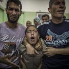 Una familia llora la muerte de un pariente, asesinado en el bombardeo a la escuela de la ONU.