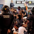 Agentes de los Mossos d' Esqueadra vigilan en El Prat a los manifestantes que han ocupado la terminal 1 del aeropuerto