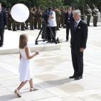 El rey Felipe de Bélgica recibe a una niña con un globo durante el acto.