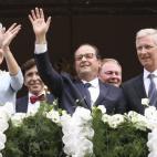 Los reyes de Bélgica saludan desde el balcón del Ayuntamiento de Lieja junto al presidente de Francia.