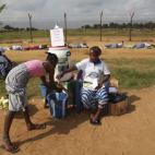 Una joven se lava las manos durante un programa de sensibilización para evitar la fiebre del ébola en Monrovia (Liberia).