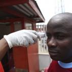 Un liberiano se toma la temperatura con un termómetro Micro Life, con el que se evita el contacto directo con la piel para impedir el contagio.