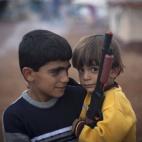 Dos niños sirios, que huyeron con sus familias de la violencia en su comunidad, posan en un campamento para desplazados, cerca de la aldea de Atmeh y de la frontera con Turquía, el jueves 8 de noviembre de 2012 (AP Foto/ Khalil Hamra)