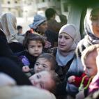 Una familia abandona su hogar tras el ataque de un tanque del ejército sirio en contra del edificio en Idlib, en el norte de Siria, el domingo 4 de marzo de 2012. La ONU revela que miles de refugiados han cruzado la frontera hacia el Líbano hu...