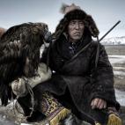Autor de Reino Unido - Viajes: Un cazador en Mongolia, con un águila.