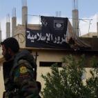 Un soldado sirio pasa por delante de una bandera del ISIS en Palmira tras su liberación