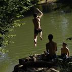 La gente se relaja y se refresca de las altas temperaturas en el río Arga, en Pamplona, donde están alcanzando los 40º.