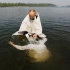 Un sacerdote ortodoxo bautiza a una mujer en el río Yenisei durante una ceremonia que marca la cristianización del país, en Siberia, Rusia. 