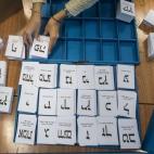 Una responsable de mesa coloca las papeletas de voto en un colegio electoral de Haifa.