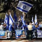 Grupos cruzados de militantes cantan el himno de Israel a las puertas de un centro de votación en la capital, Tel Aviv.