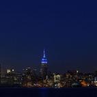 El Empire State neoyorquino visto desde Hoboken (Nueva Jersey). El emblemático rascacielos se ha iluminado esta noche de azul para dar visibilidad a los que sufren autismo.