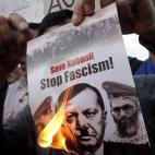Atenas (Grecia). Un manifestante quema una imagen del presidente turco, Erdogan, en la que se lee: "¡Salvad a Kobane! ¡Parad el fascismo!"