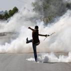 Un manifestante palestino devuelve de una patada una lata de gas lacrimógeno a las tropas israelíes que se la habían lanzado durante una protesta en el asentamiento judío de Ofra, cerca de Ramala.