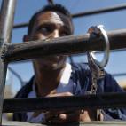 Un refugiado somalí es esposado a una barra de una camioneta tras ser interrogado en una comisaría emplazada en el estadio de Kasarani, Nairobi. La Policía de Kenia detuvo a cerca de 4.000 personas durante la última semana en Nairobi, en una...