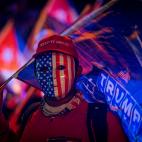 Un simpatizante de Donald Trump viste una careta con la bandera estadounidense y una gorra que dice "Mant&eacute;n (Am&eacute;rica) grandiosa".