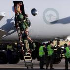 Miembros de la tripulación de un avión de patrulla marítima AP-3C Orion suben a pie por una escalera a su llegada a Perth este jueves tras el vuelo de Malaysia Airlines en un área en el sur del Océano Índico.