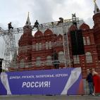 Workers fix a banner reading "Donetsk, Lugansk, Zaporizhzhia, Kherson - Russia!" on top of a construction installed in front of the State Historical Museum outside Red Square in central Moscow on September 29, 2022. - Russia will formally annex ...