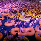 Un grupo de ba&ntilde;istas se refresca mientras asiste a una actuaci&oacute;n en una piscina de Wuhan, en la provincia china de Hubei.