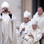 Un cardenal toma una foto antes del comienzo de la ceremonia de canonización