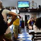 Numerosos brasileños ven la tele en un bar cerca del estadio de Maracaná en Río de Janeiro."Los residentes de Río tendrán que trabajar duro para mantener las calles limpias y los vasos de cerveza llenos, y la fiesta será grande, pero la re...