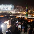 La gente observa los fuegos artificiales de Maracaná desde el tejado de su casa en la favela de Mangueira.