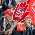 Un hombre sostiene un cartel en el que se lee 'Salario mínimo' y 'Ningún salario por debajo de 8,50 euros por hora', durante una manifestación en Nuremberg, Alemania.