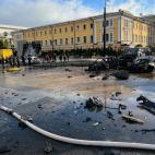 Rescue workers survey the scene of a Russian attack on Kyiv, Ukraine on Monday, Oct. 10, 2022. Two explosions rocked Kyiv early Monday following months of relative calm in the Ukrainian capital. (AP Photo/Adam Schreck)