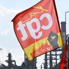 A CGT Union flag is seen as trade unionists and striking employees gather outside the TotalEnergiesrefinery site, in Donges, western France, on October 12, 2022. - France's Prime Minister announced on October 11, 2022 the requisition of staff to...