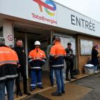 Employees stand at an entrance of the TotalEnergies fuel depot of Mardyck, near Dunkirk, northern France, on October 13, 2022, after essential striking workers were ordered by the French government to return to work. - Unions are seeking pay hik...