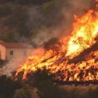 Vista del incendio destruyendo una casa en California.