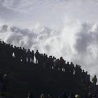 Un grupo de personas observa grandes olas en Praia do Norte, Nazaré (Portugal).