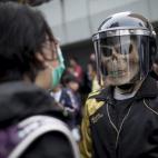 Un manifestante prodemocracia con casco y máscara, plantado frente al complejo gubernamental de Hong Kong. Tras dos meses arrastrando a multitudes de decenas de miles de personas, el principal campamento de la protesta ha sido dispersado por la...