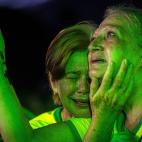 Dos señoras lloran tras conocer la derrota de Bolsonaro y una de ellas sostiene un rosario.