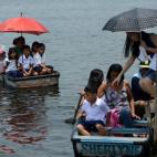 Estudiantes de primaria de filipinas montan en botes para ir a la escuela cerca de Artex Compound, en la ciudad de Malabon, en Filipinas. La foto es del 5 de junio de 2013.